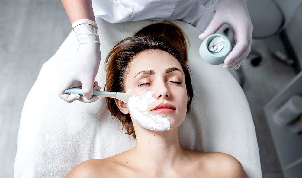 A woman with brown hair receives a facial