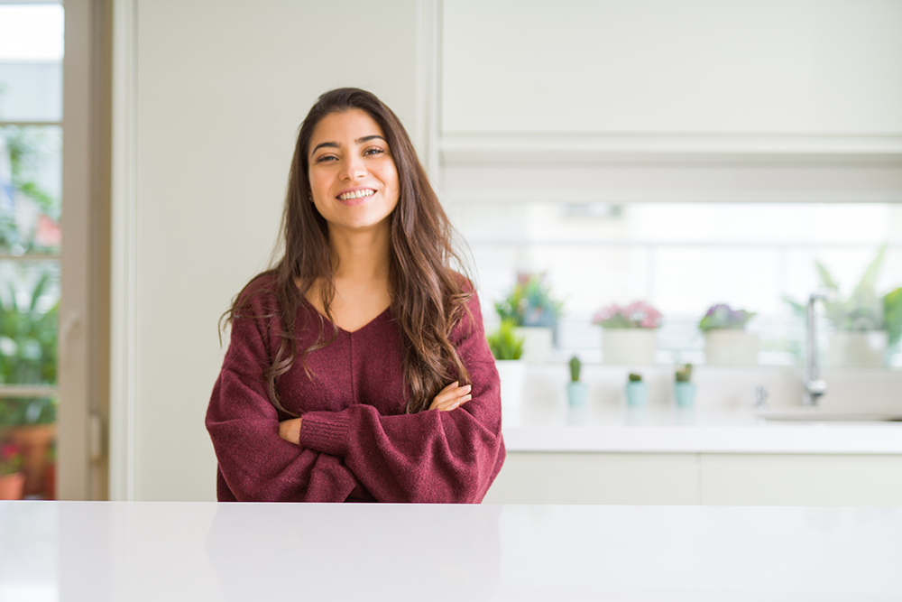 Beautiful young woman stands in kitchen