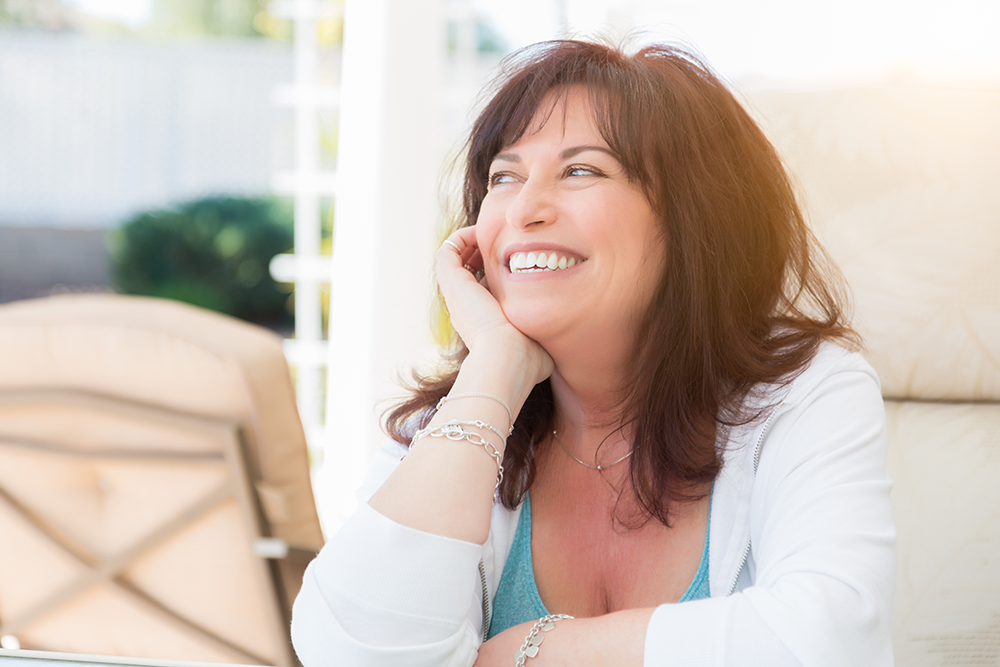 A middle aged woman smiles after receiving jeuveau